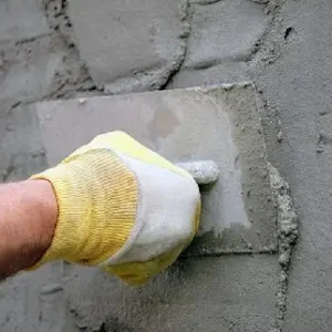 Нанесение цементного раствора на стену